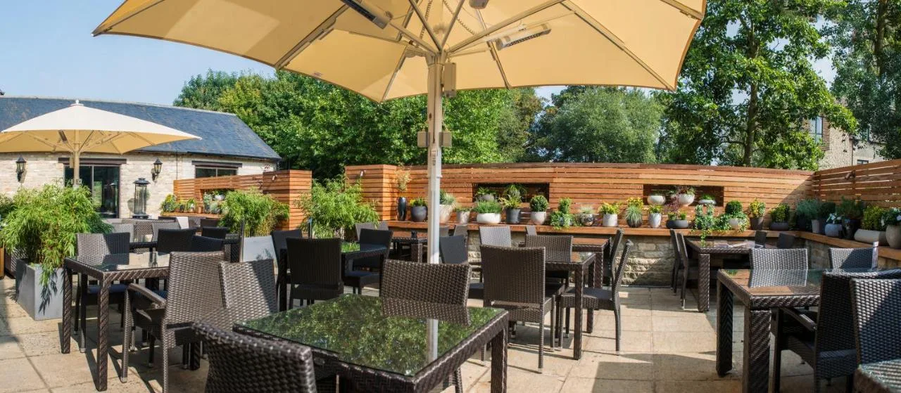 Patio terrace with tables and umbrellas in the hotel gardens